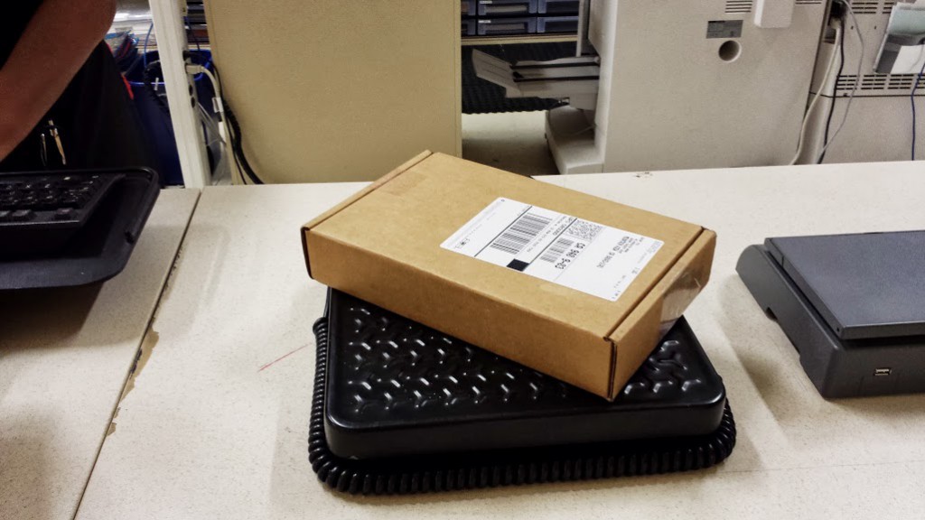 UPS mailing carton containing Google Glass sitting atop the scale at UPS